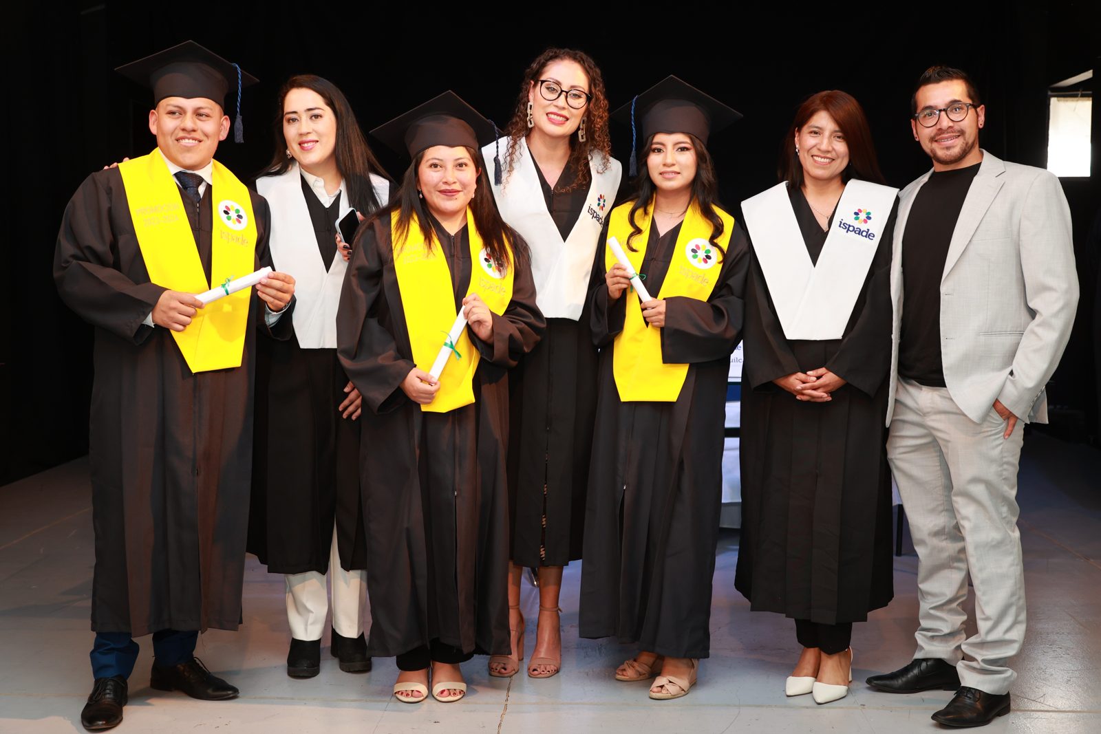 Graduados del ISPADE con sus bandas y diplomas en la ceremonia de incorporación