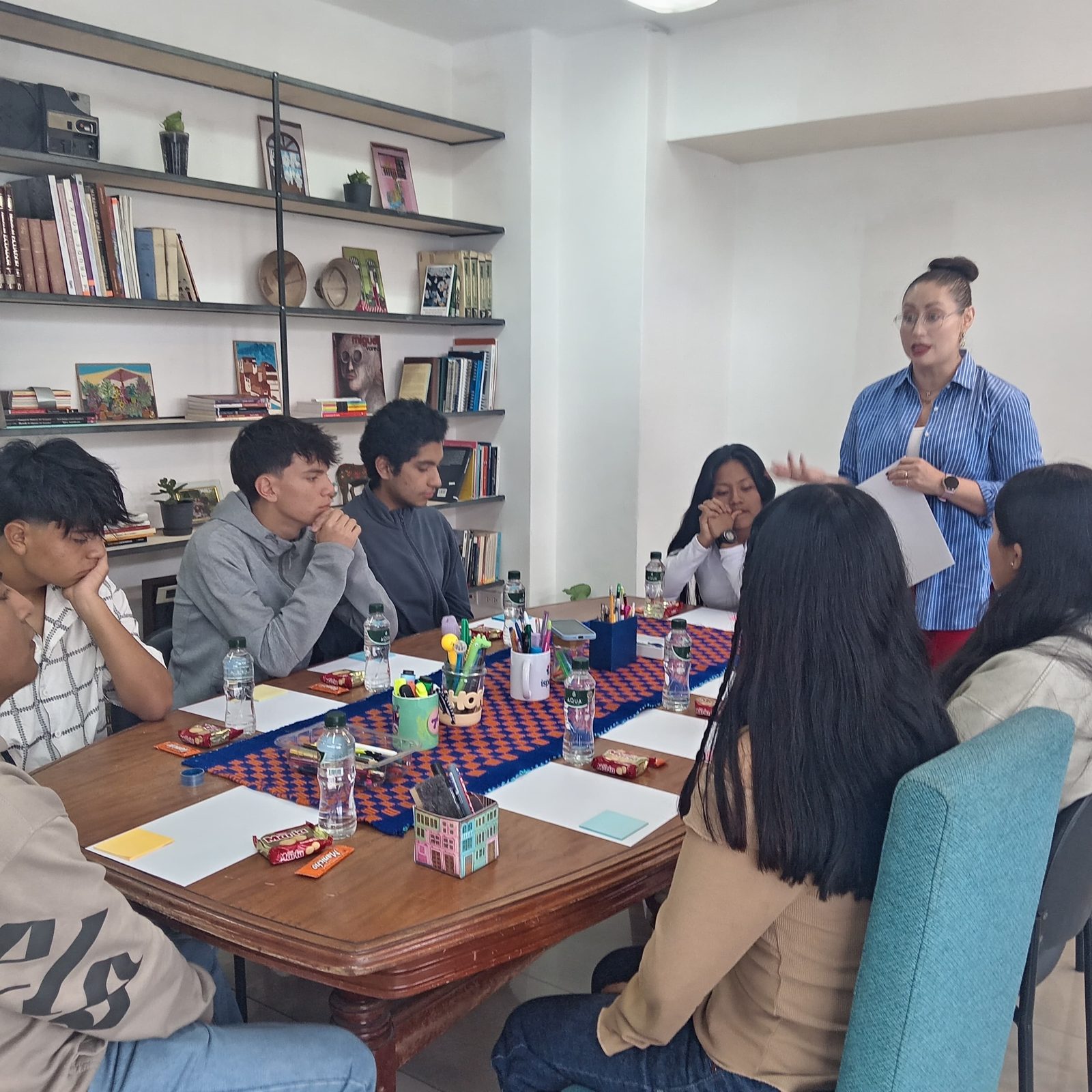 Jóvenes conversan alrededor de una mesa de trabajo durante un encuentro de investigación de Escuchativa