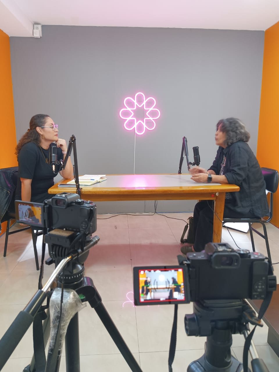 Entrevista del podcast Escuchativa grabada con dos cámaras frente a la mesa de micrófonos